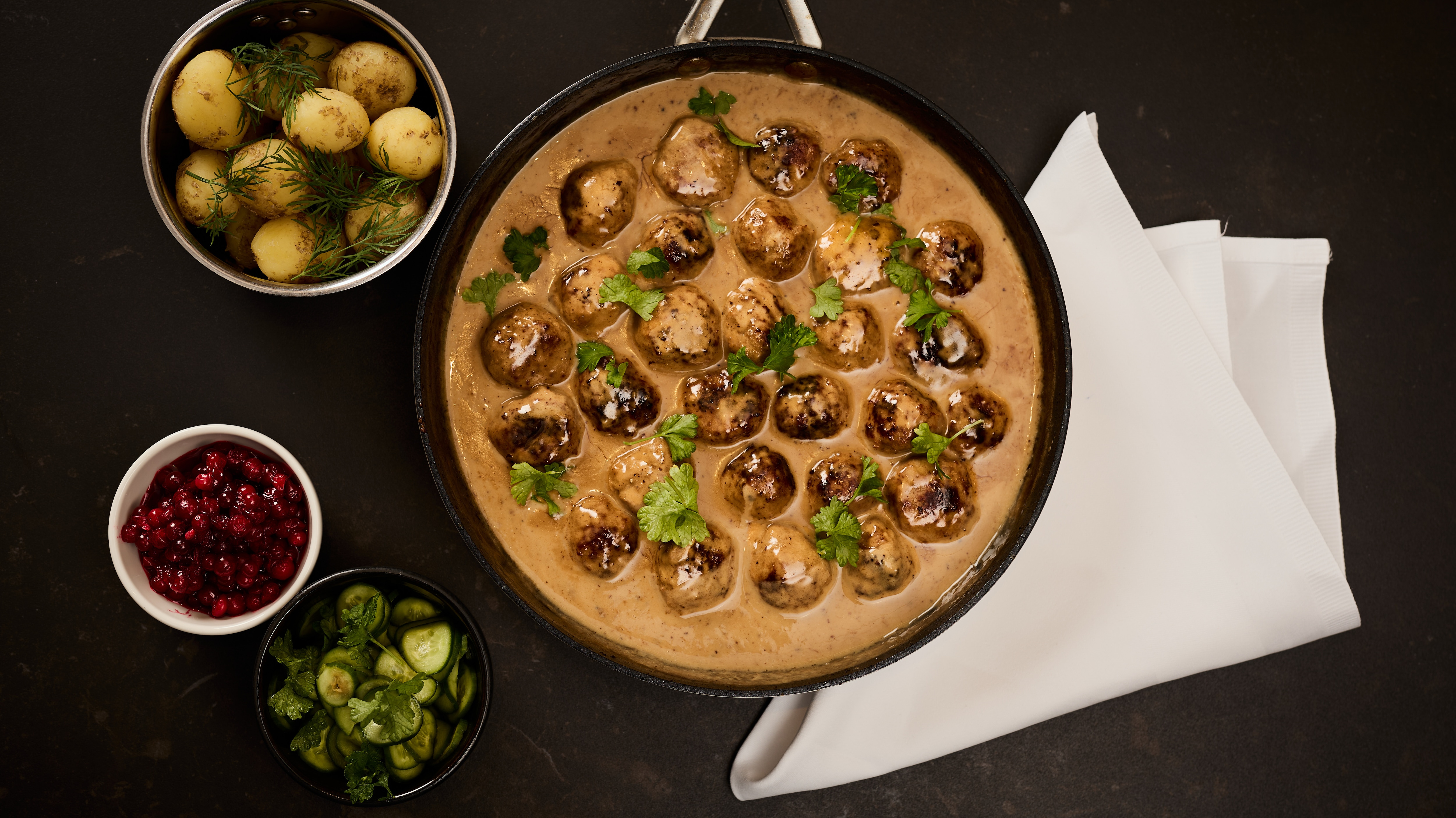 Köttbullar med gräddsås, rårörda lingon och pressgurka